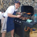 Dr. O grills for neighbors at his church's community day